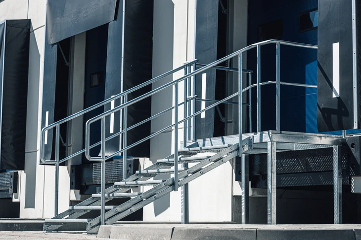 Scène d'affaires en intérieur moderne avec deux professionnels debout sur une mezzanine ou passerelle d'immeuble de bureaux