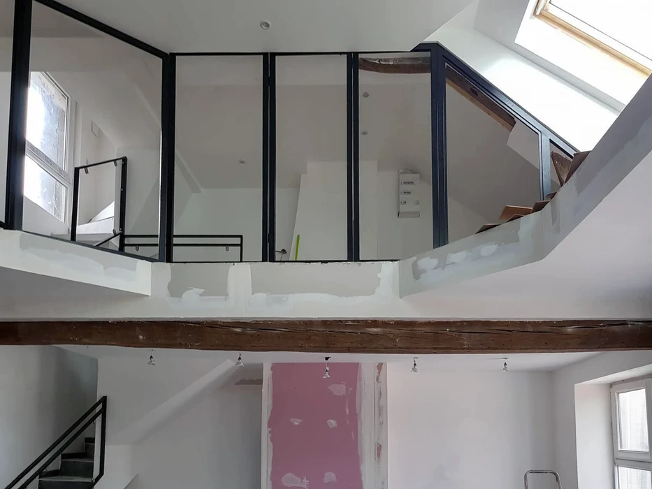 Intérieur résidentiel moderne avec escalier hélicoïdal métallique, mur en briques apparentes éclairé, sol en résine blanche brillante