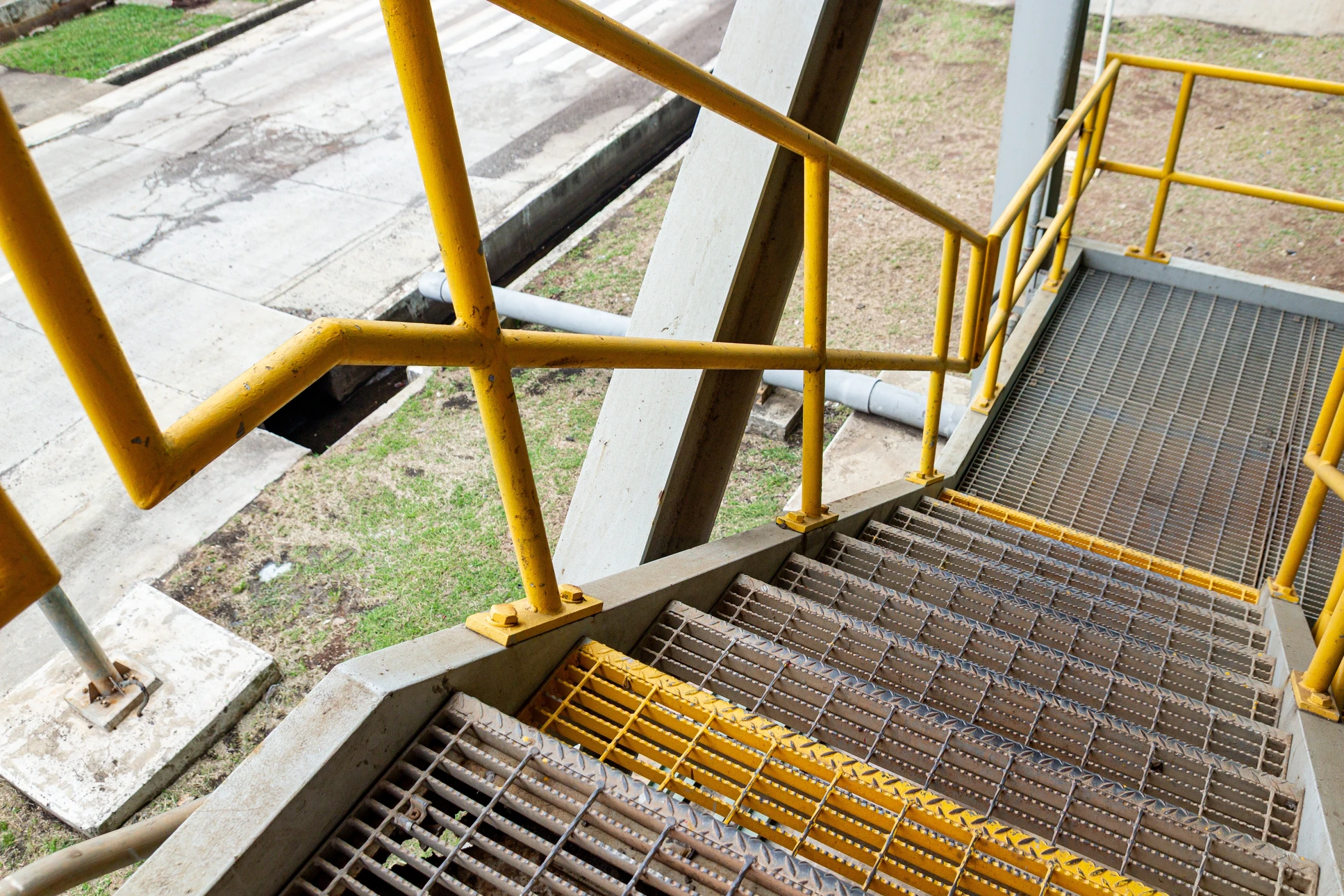 Escalier courbe moderne dans hall d'accueil luxueux avec colonnes cylindriques en marbre, sol poli réfléchissant et éclairage architectural sophistiqué