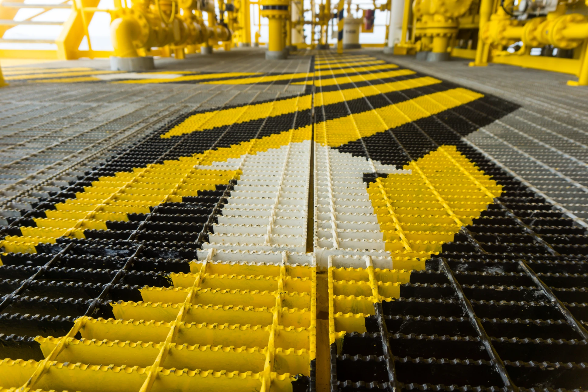 Soudeur professionnel en action dans un atelier sombre, portant masque de protection et vêtements de sécurité, réalisant une soudure sur métal avec projection d'étincelles lumineuses
